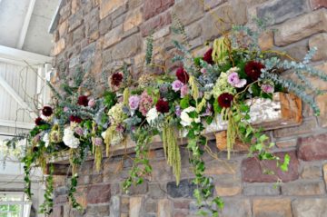 Romantic and elegant mantle design with greenery and pops of red, blue, purple and white