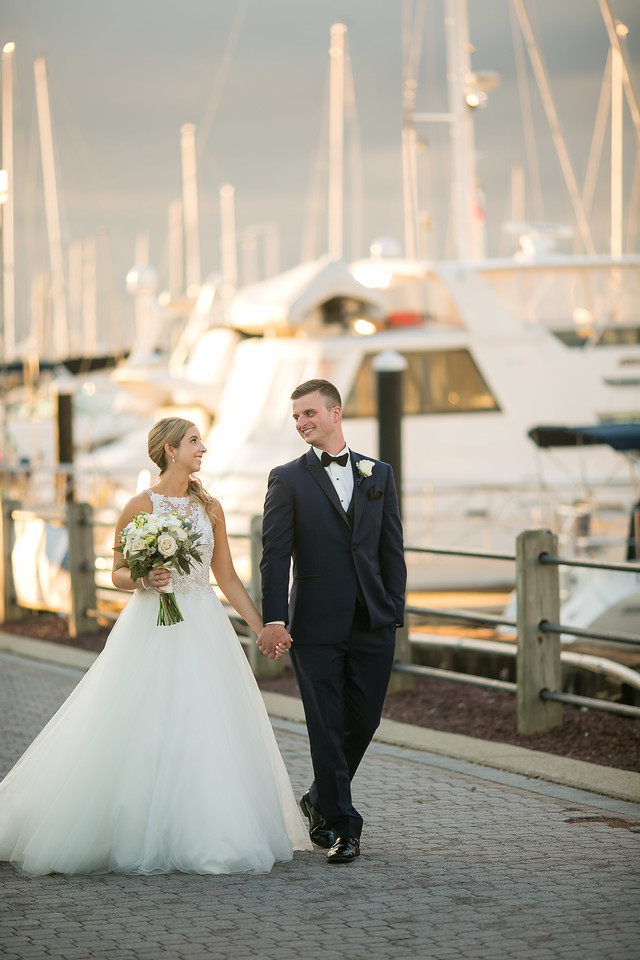 Our bride and groom looked so chic on their wedding day as they walked along the pier where dozens of boats were docked.