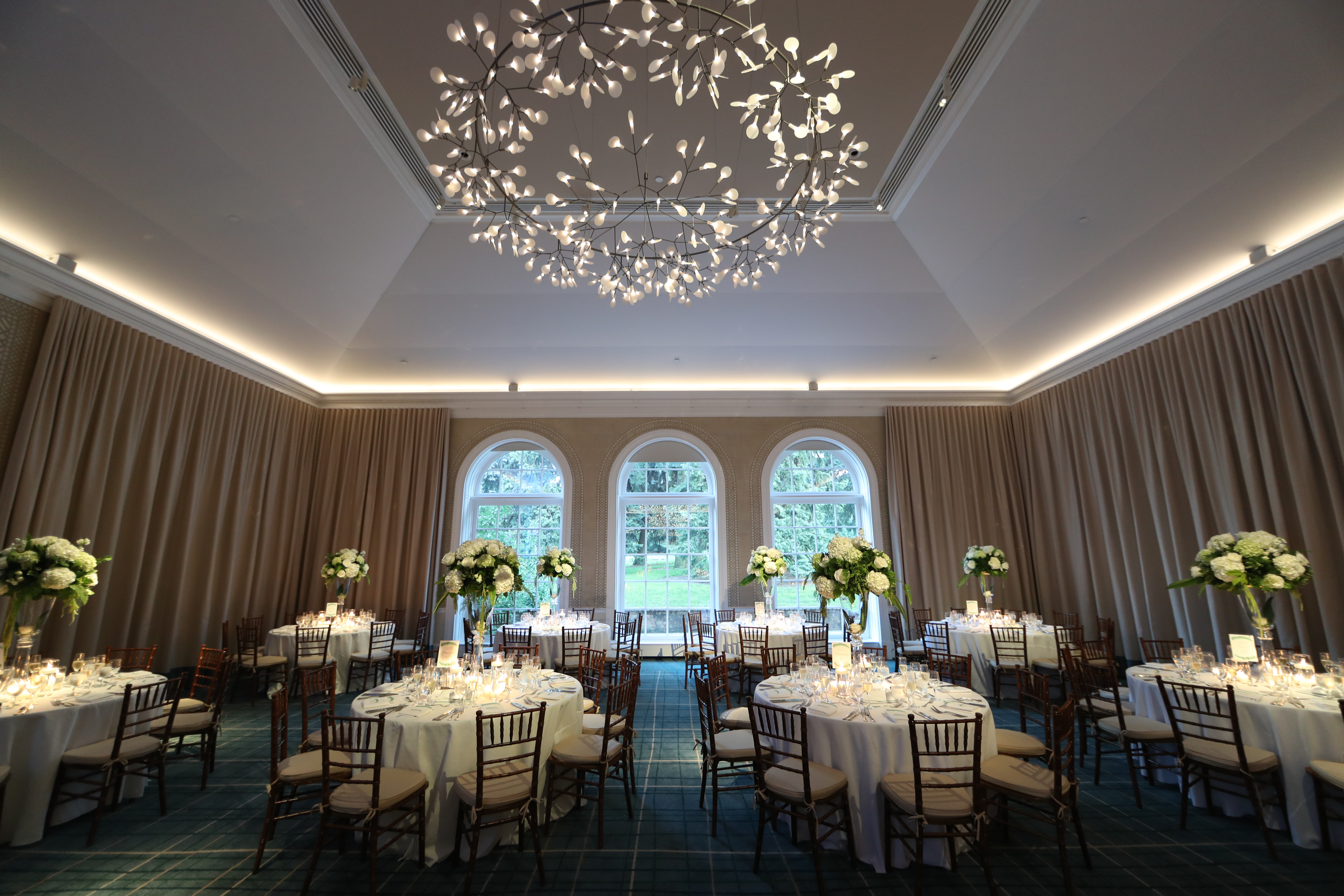 The chic ballroom at The New York Botanical Gardens that we designed using greenery and white roses for our bride and groom. See all the beautiful details on our blog!
