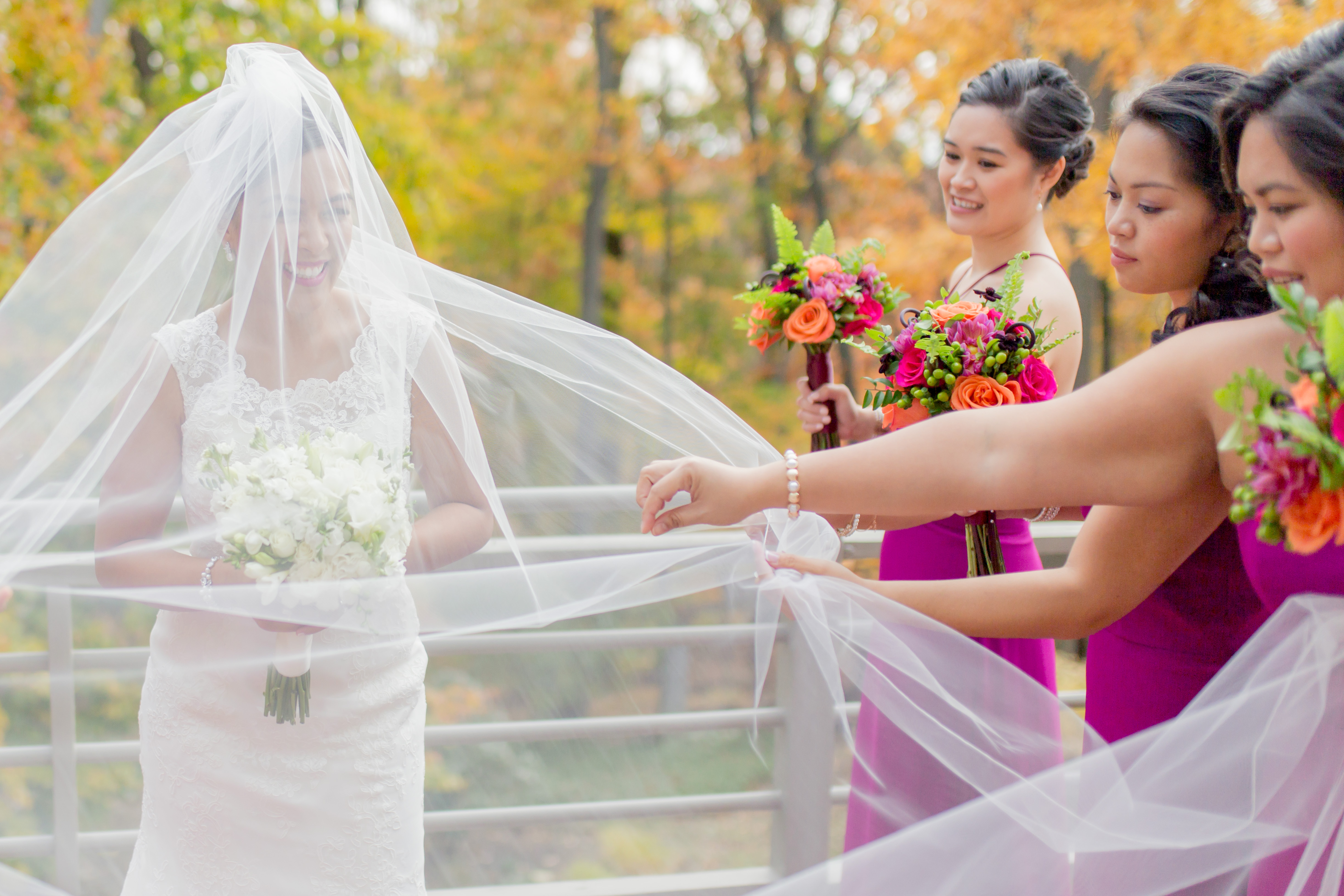 bride with long veil standing with bridesmaids