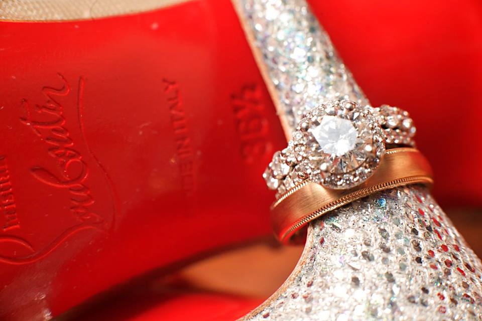 diamond engagement ring and gold wedding band on heel of shoe