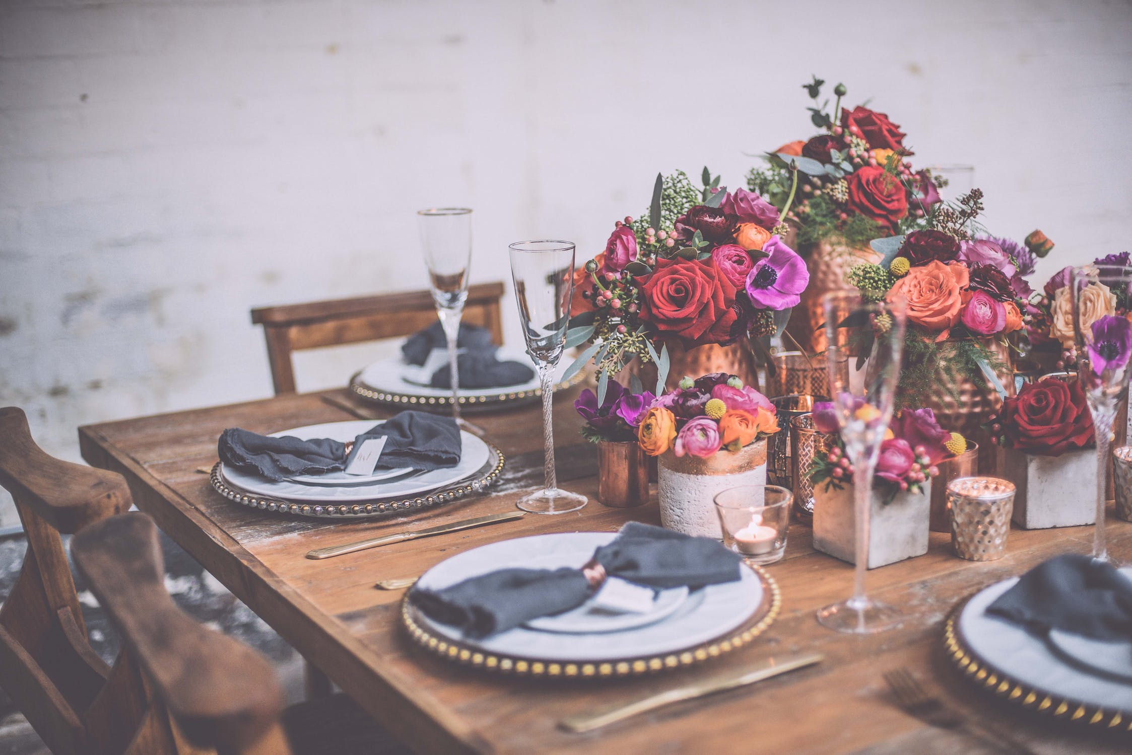 farmhouse table with gold beaded charger and bright flowers