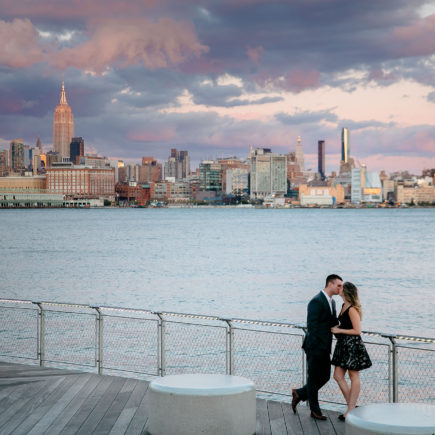 couple kissing by water and NYC skyline