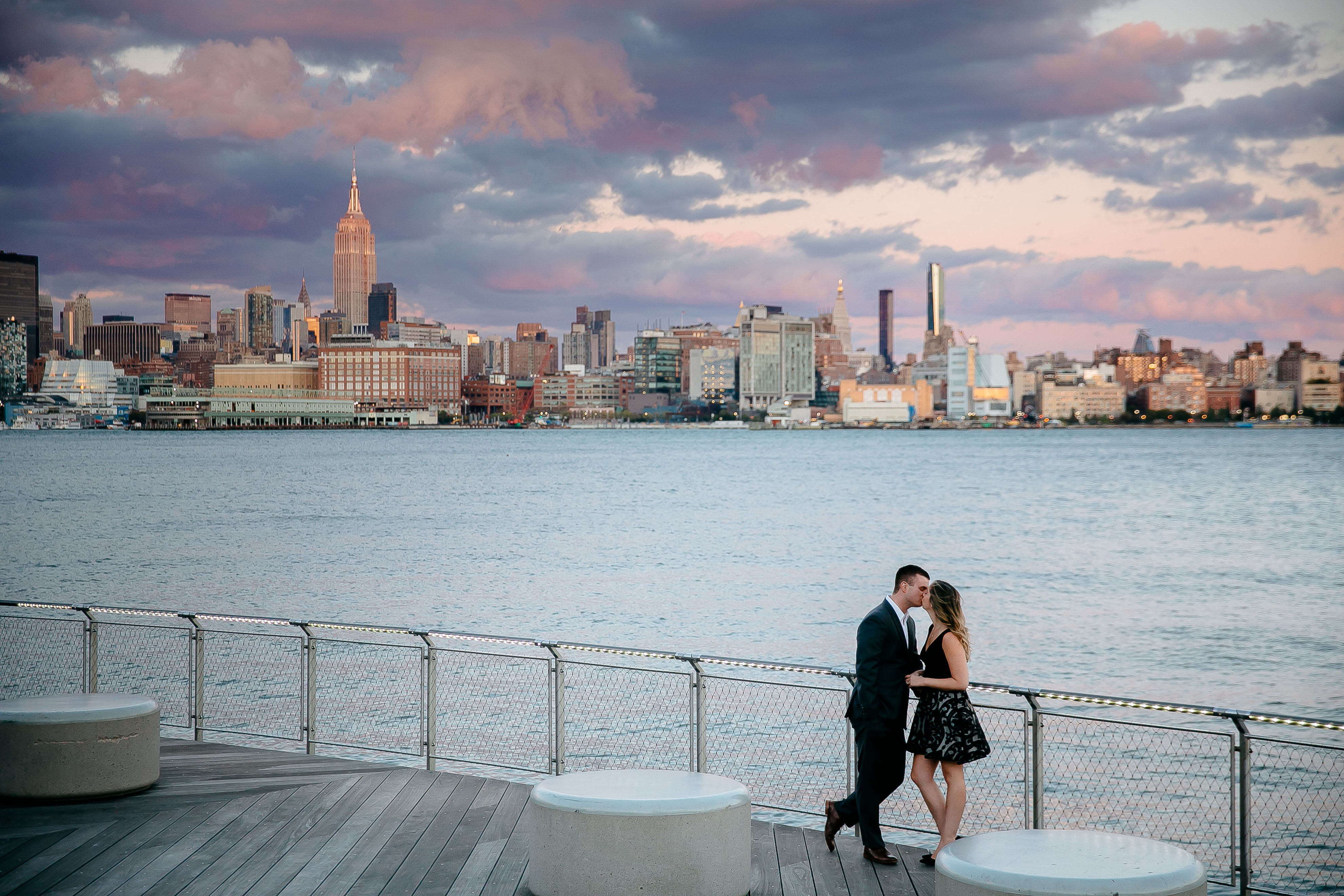 couple kissing by water and NYC skyline