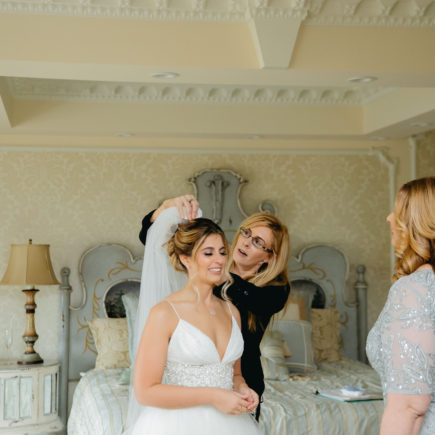 wedding planner placing veil on bride's head