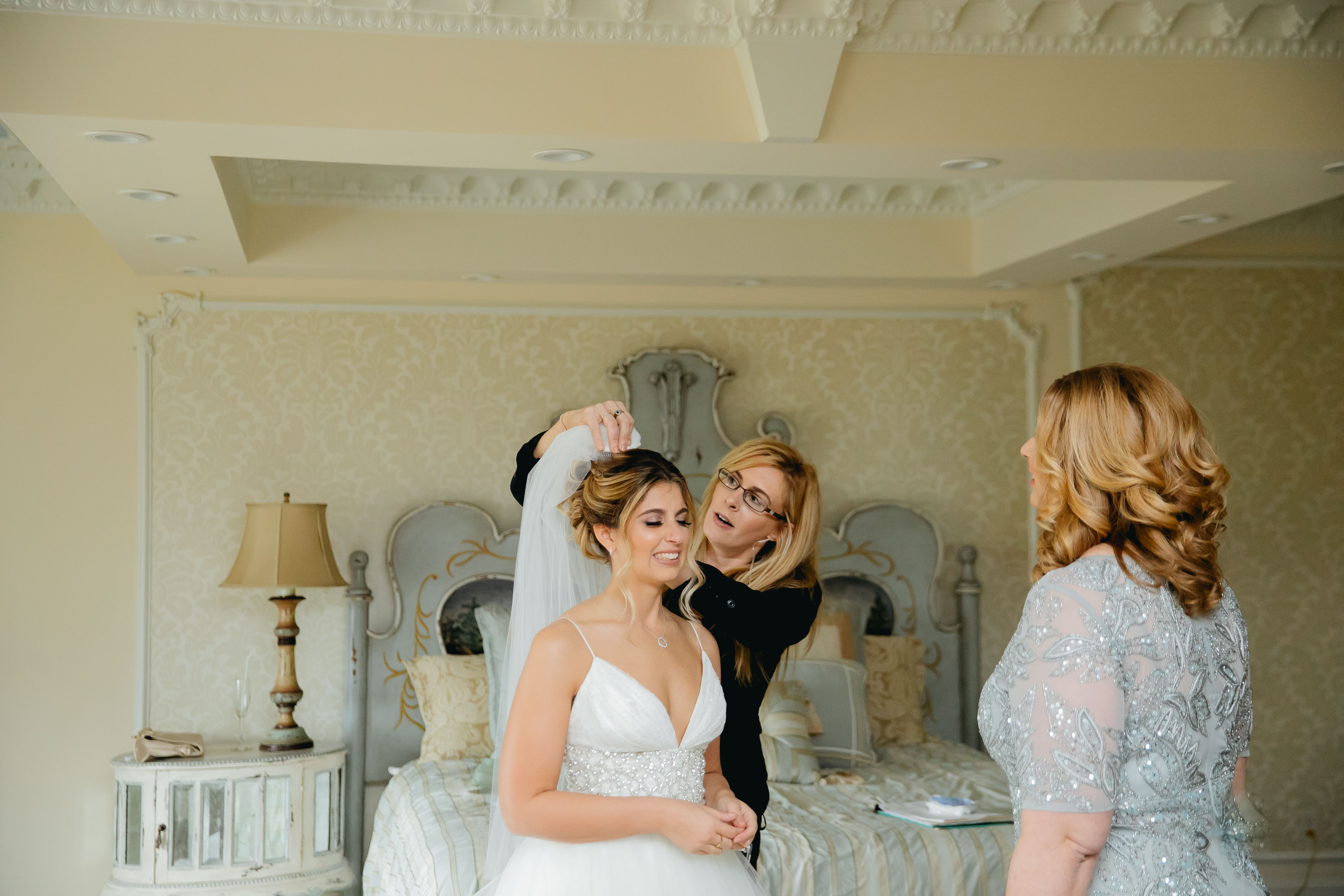 wedding planner placing veil on bride's head