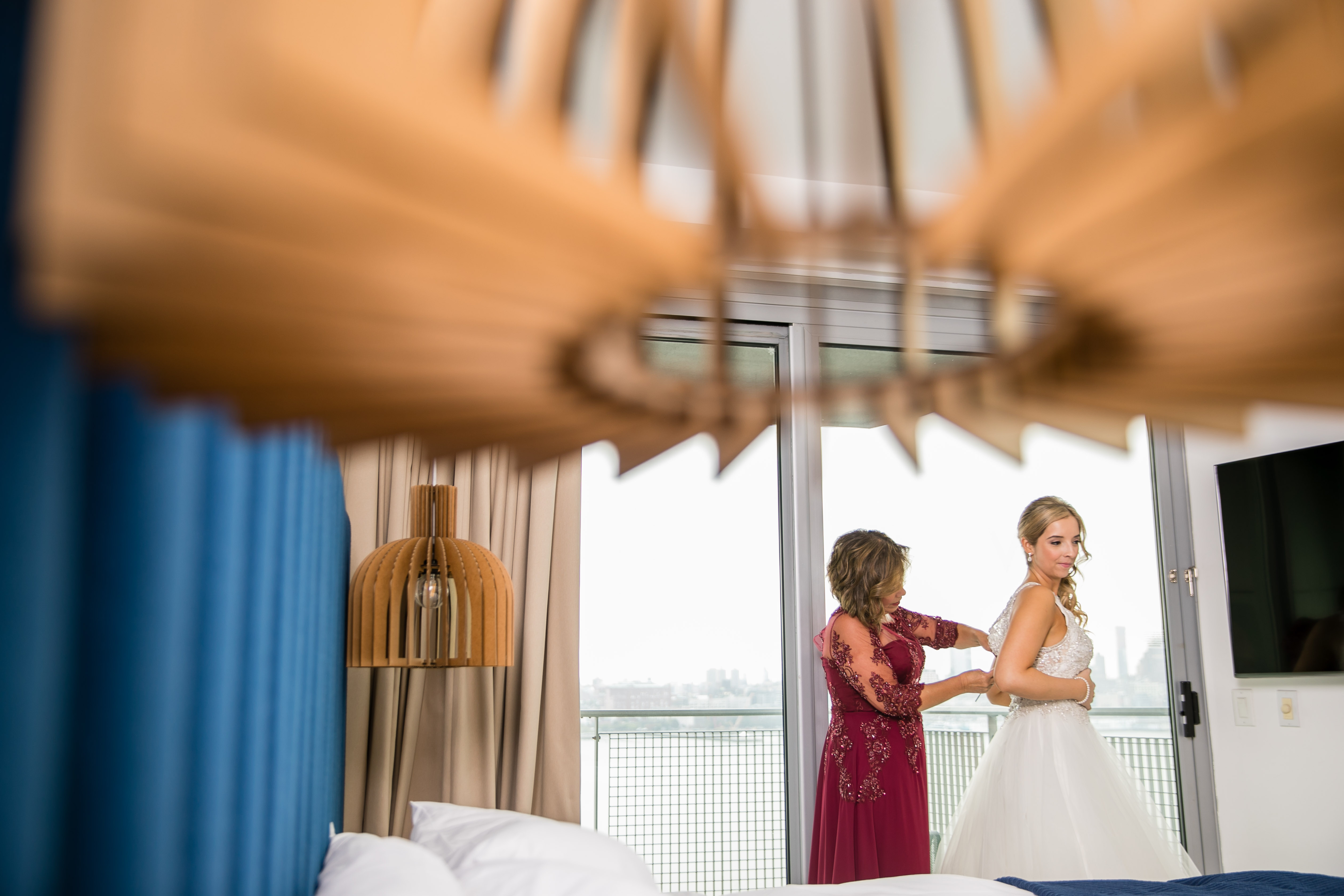 bride getting into gown with help from mother of the bride