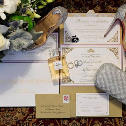 gold and white wedding invitations with red bottom shoes