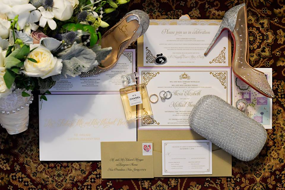 gold and white wedding invitations with red bottom shoes