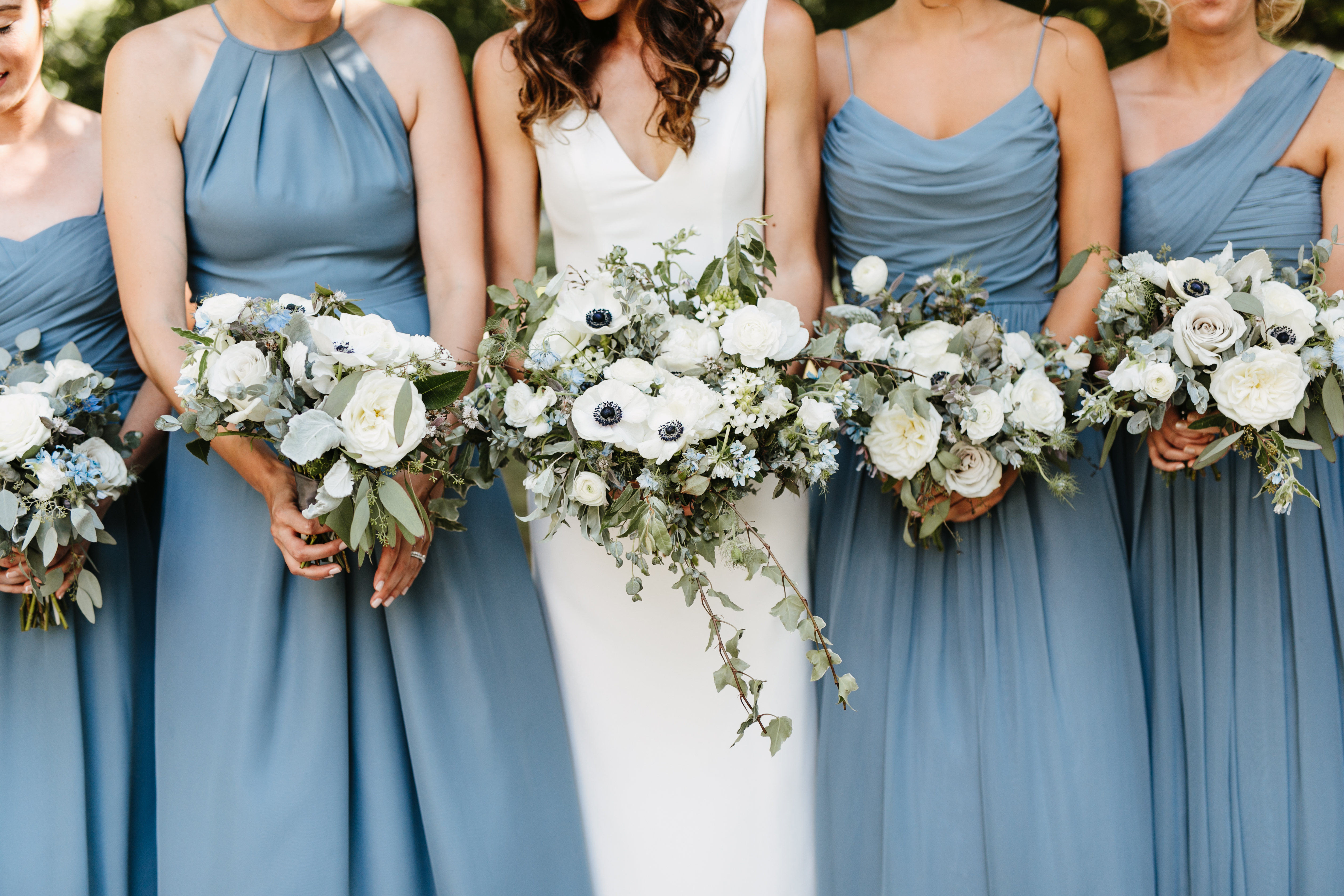 bridesmaids in blue holding bouquets
