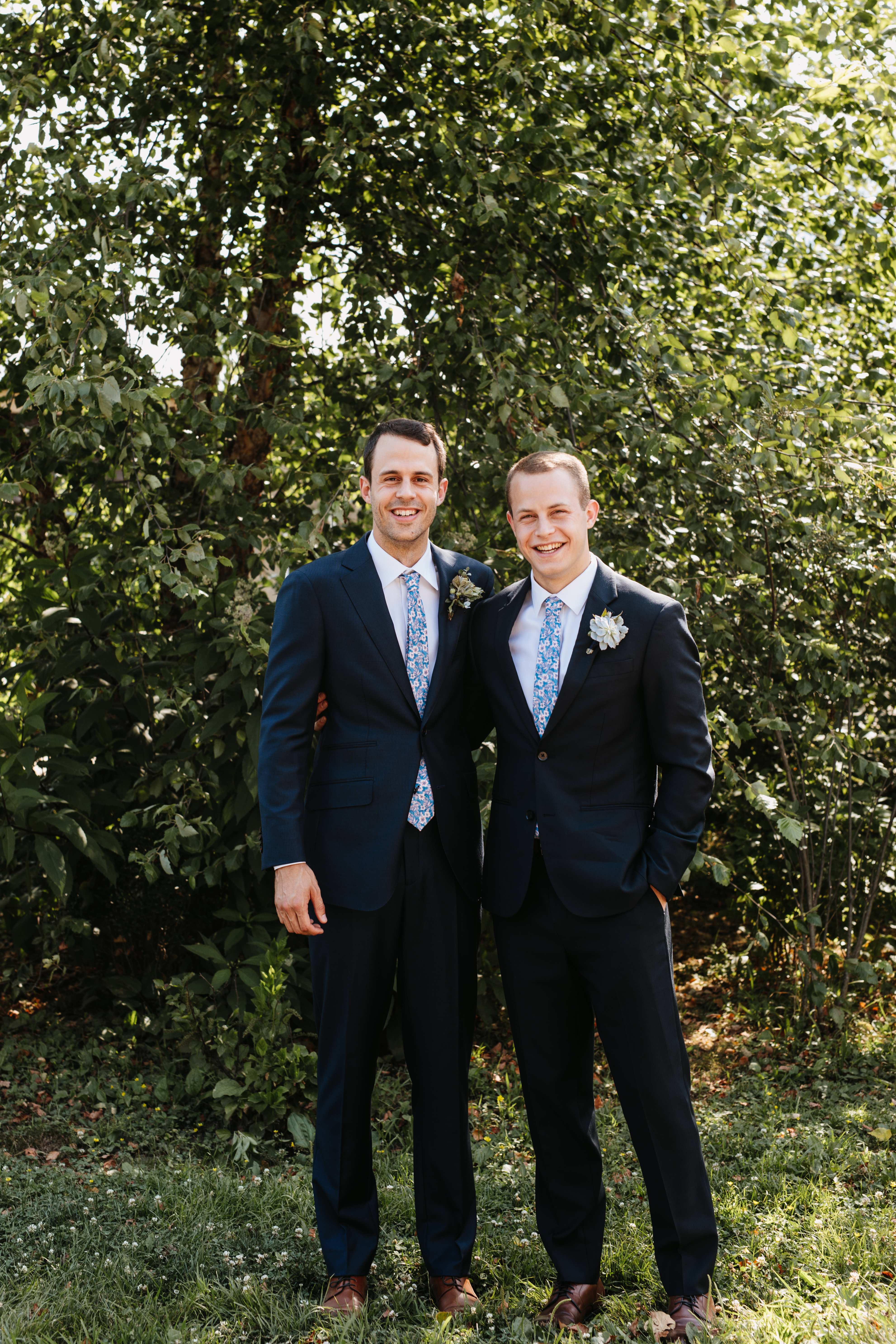 groom and groomsmen in navy suits with paisley ties