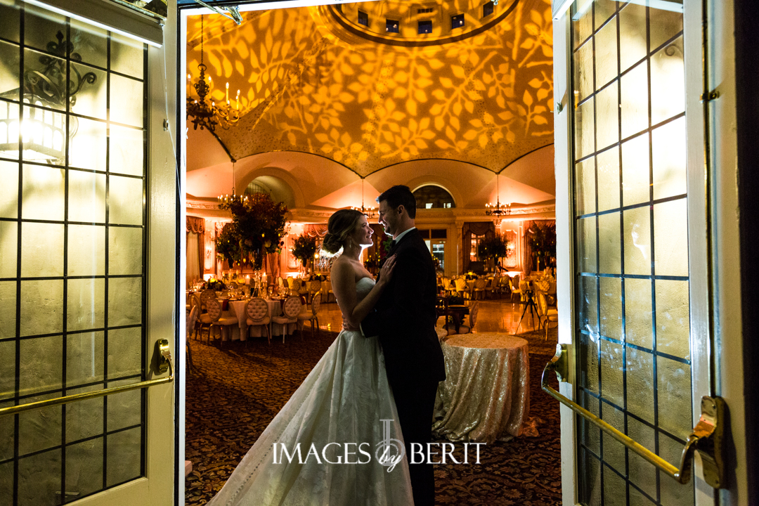 bride and groom standing in golden ballroom