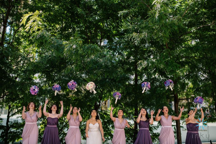 bride and bridesmaids tossing bouquets in air outside