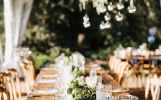 long farmhouse table with greenery hanging above for a wedding