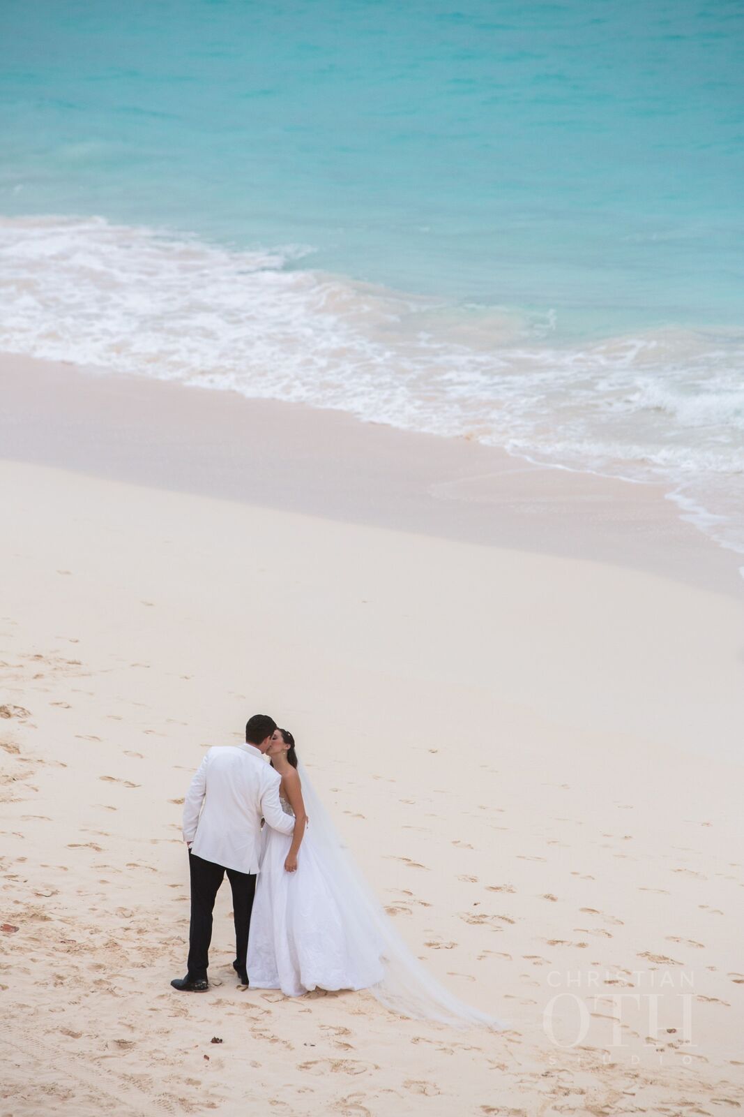 bride and groom kissing on beach