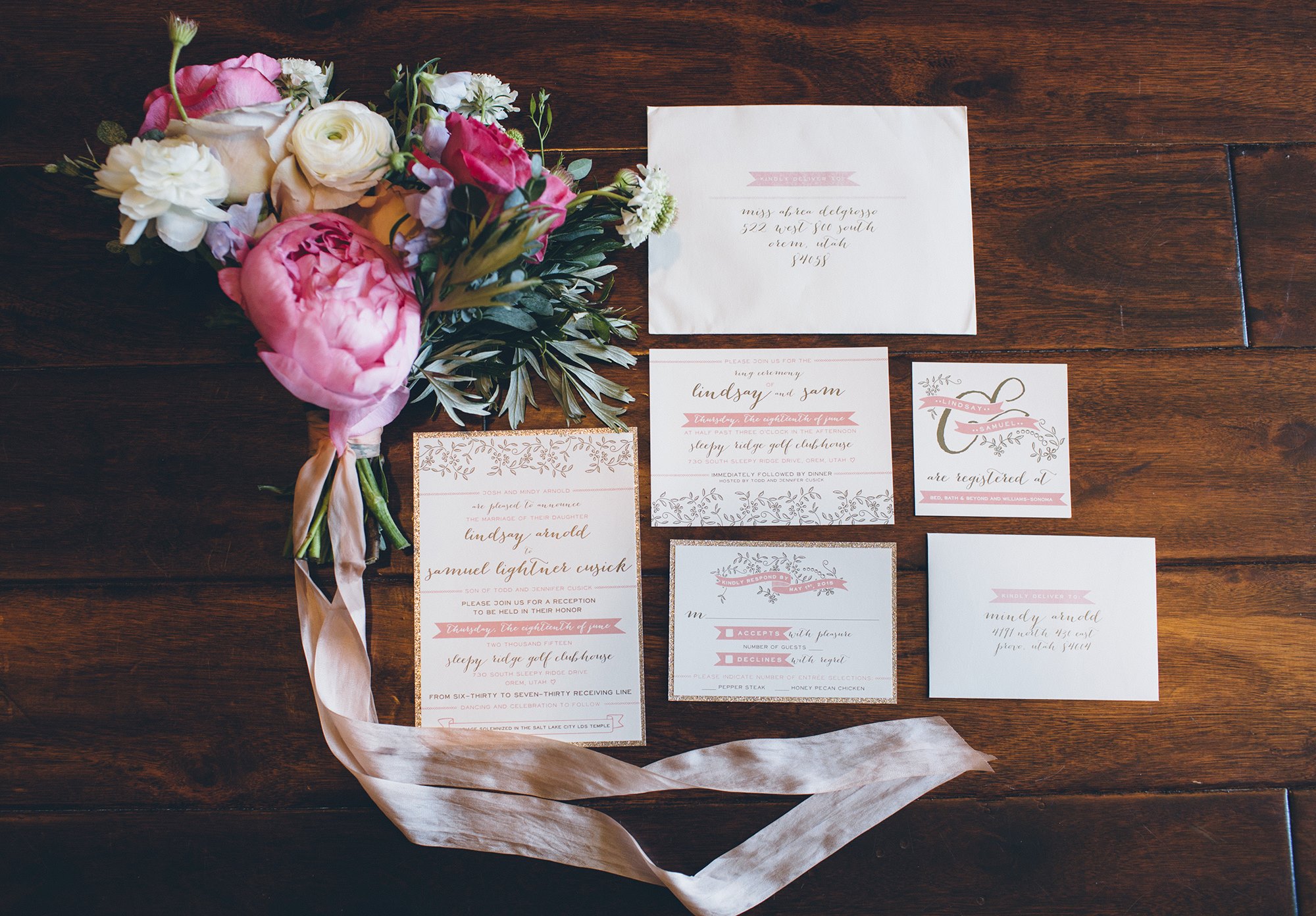 pink and white wedding invitations and floral bouquet