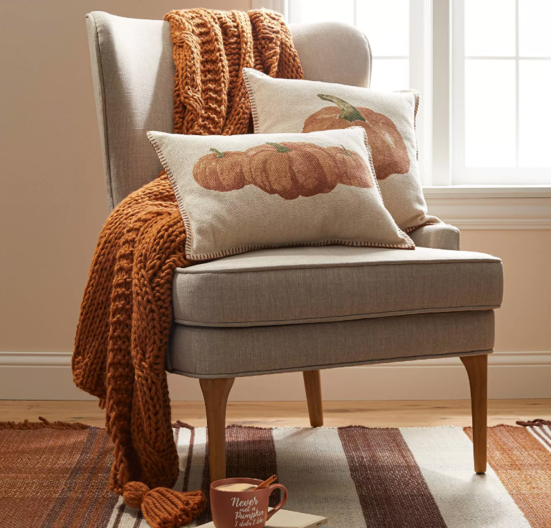 chair with orange blanket and pumpkin pillows