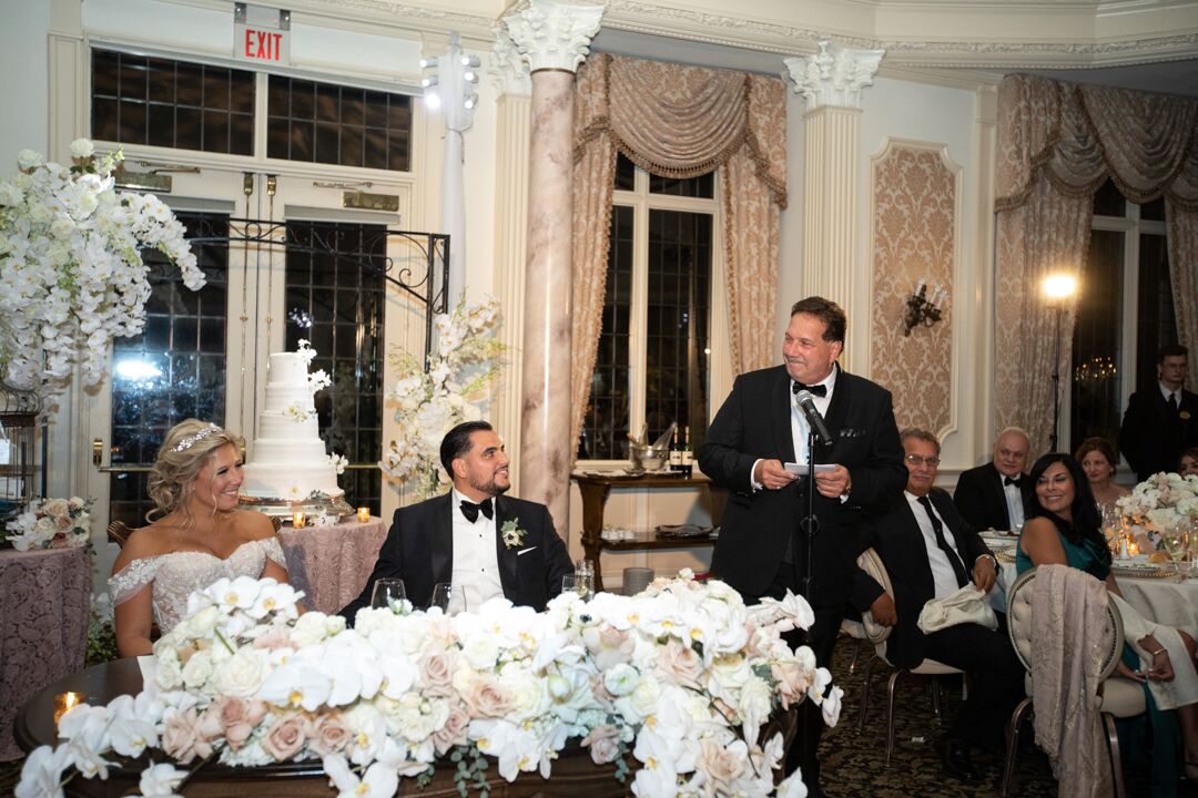 bride and groom listening to father of the bride wedding toast