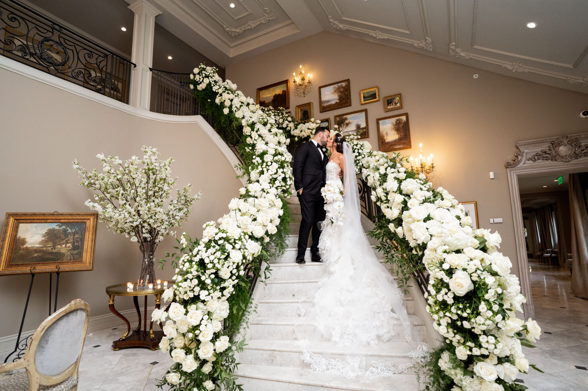 white and green floral staircase with bride and groom
