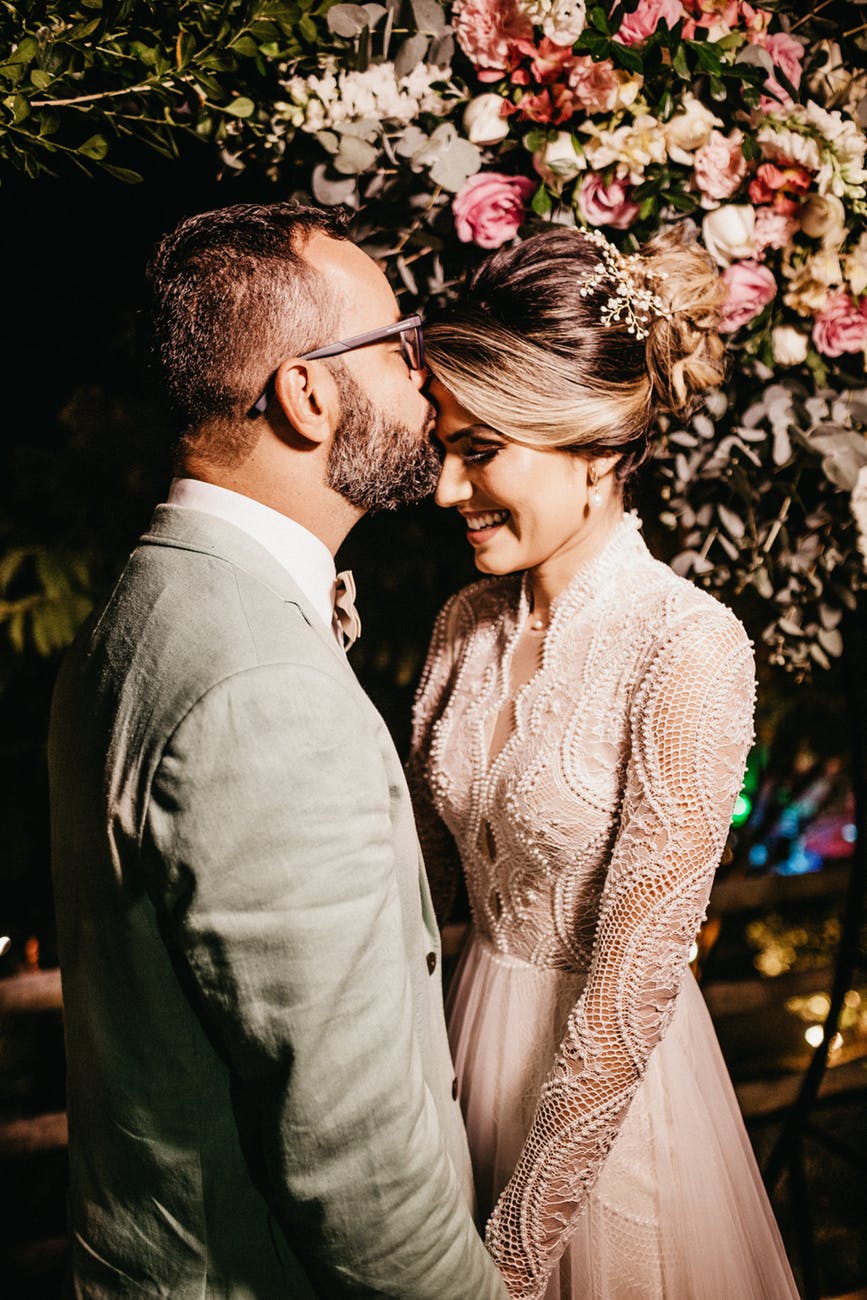 groom kissing bride on forehead