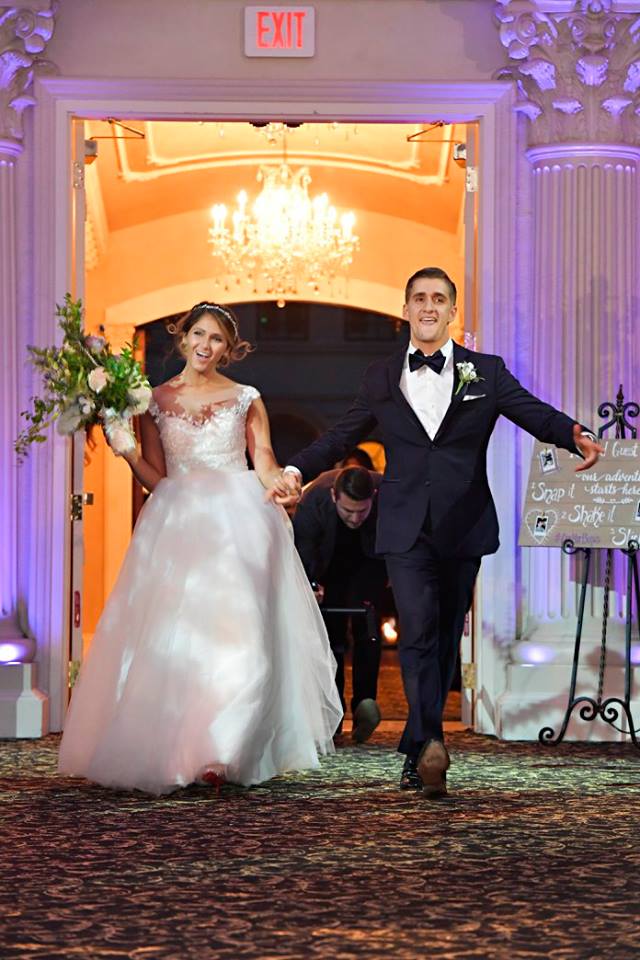 bride and groom walking into reception hall