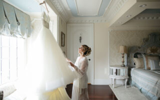 bride looking at her gown in window
