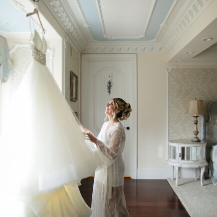 bride looking at her gown in window