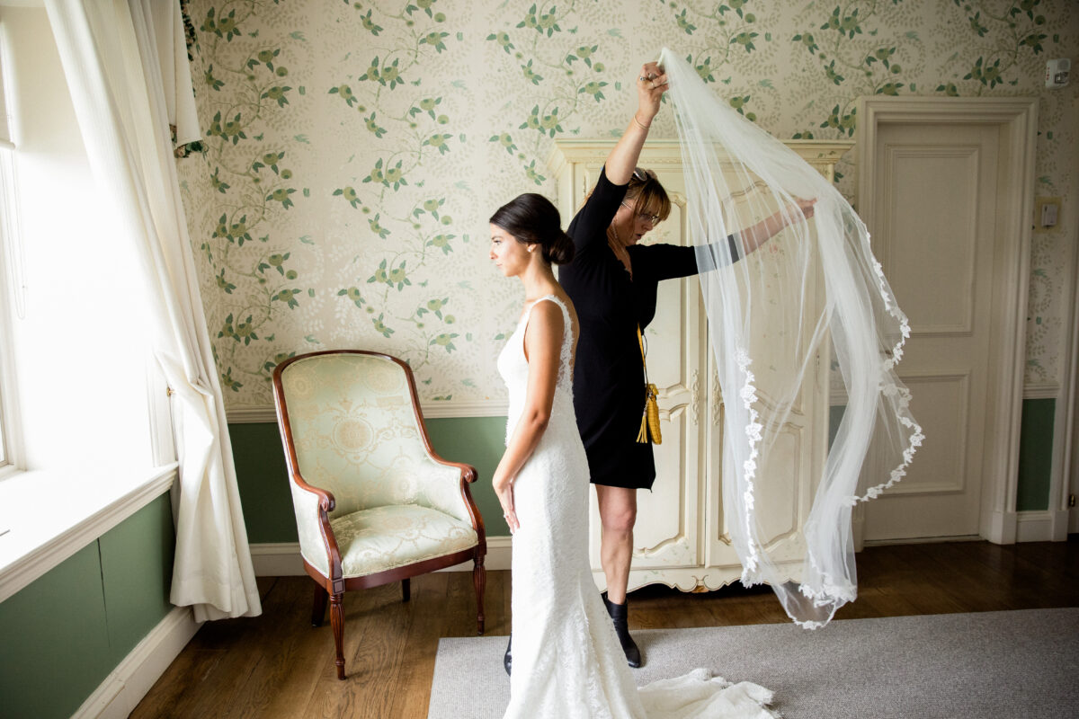 bride with long veil and wedding planner