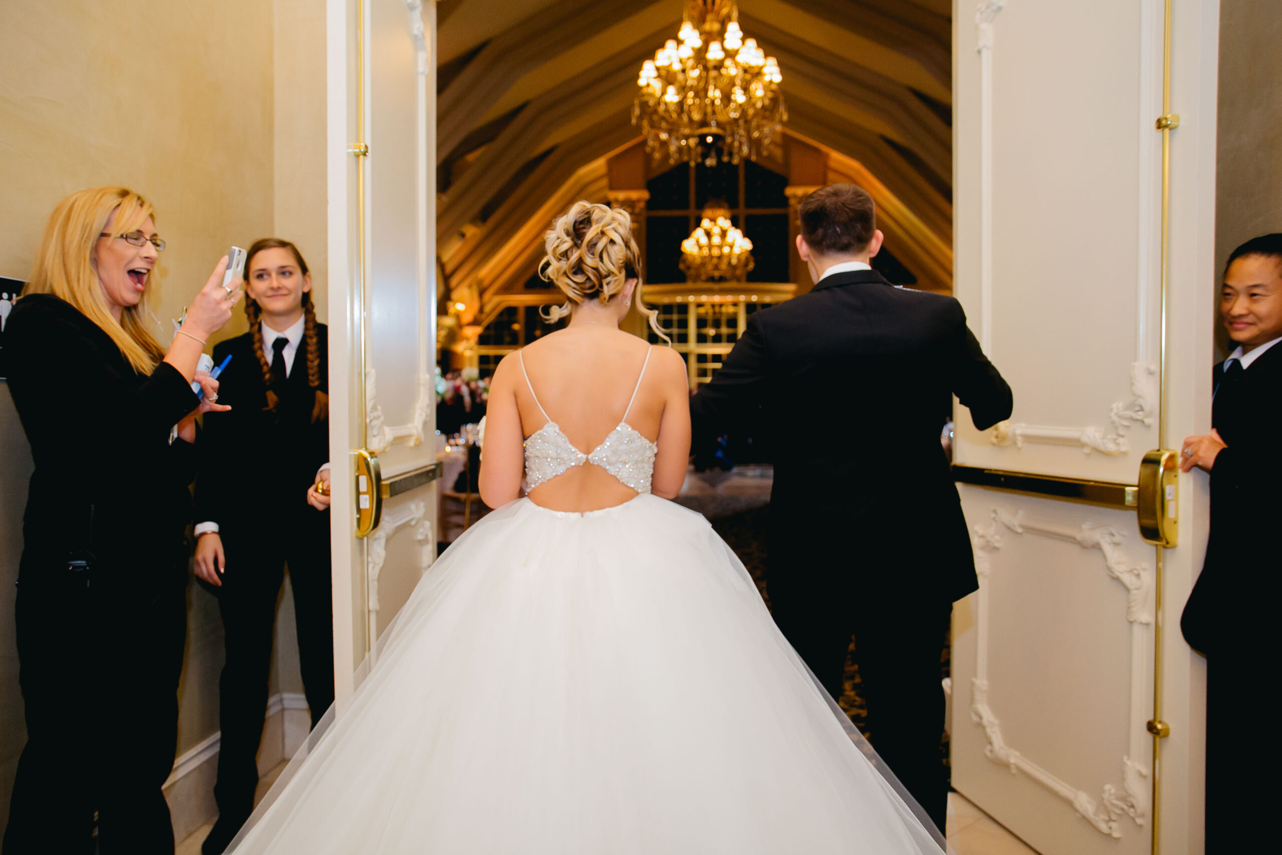bride and groom entering ballroom