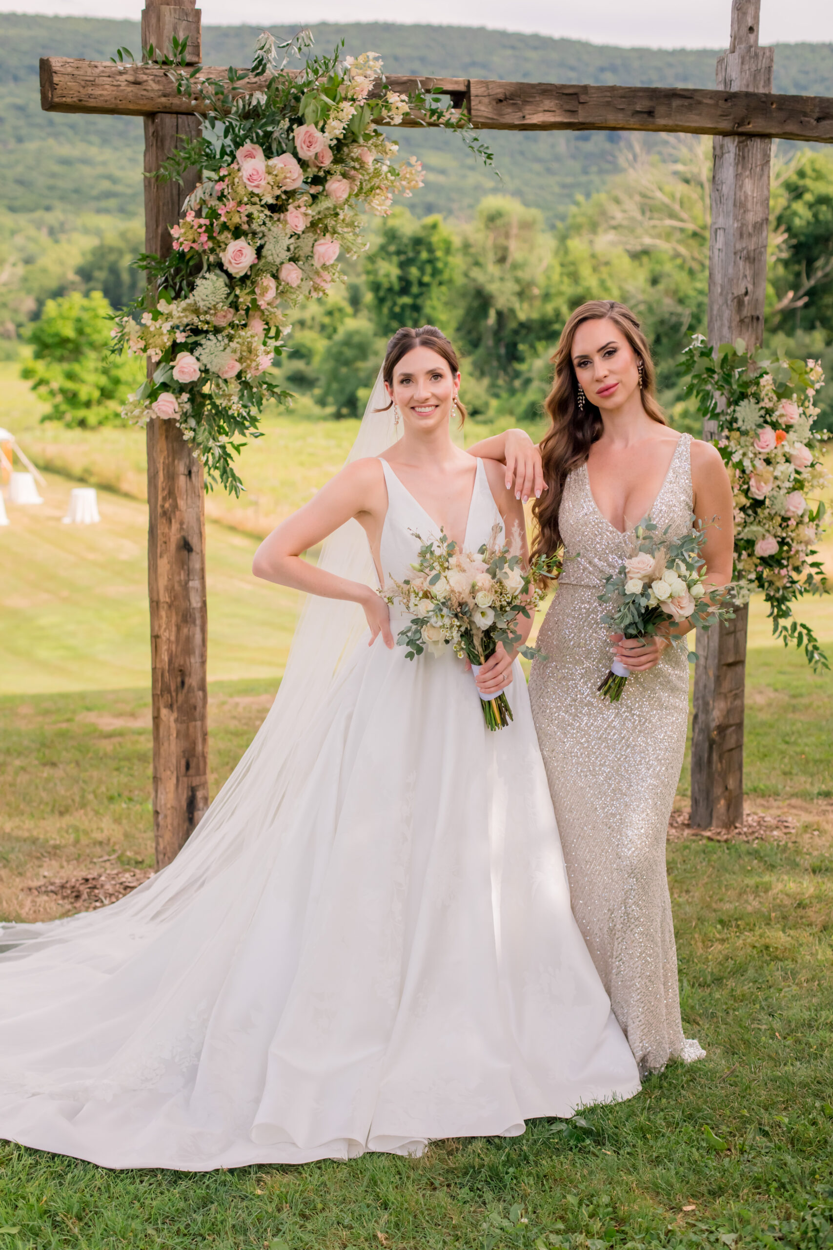 bride and bridesmaid under arch