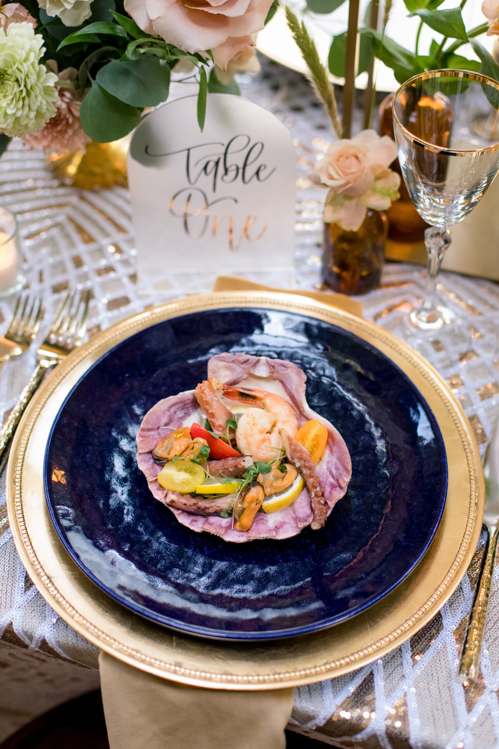 blue plate and gold charger with food at wedding