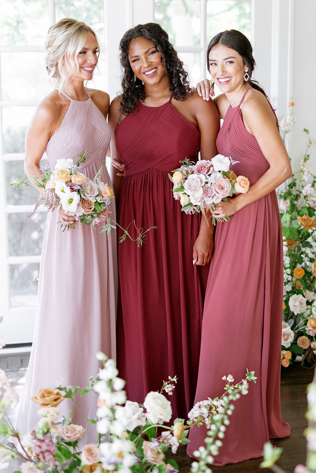 three bridesmaid dresses wearing chiffon in pink red and rose