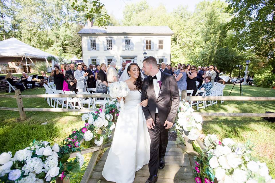 bride and groom walking across bridge