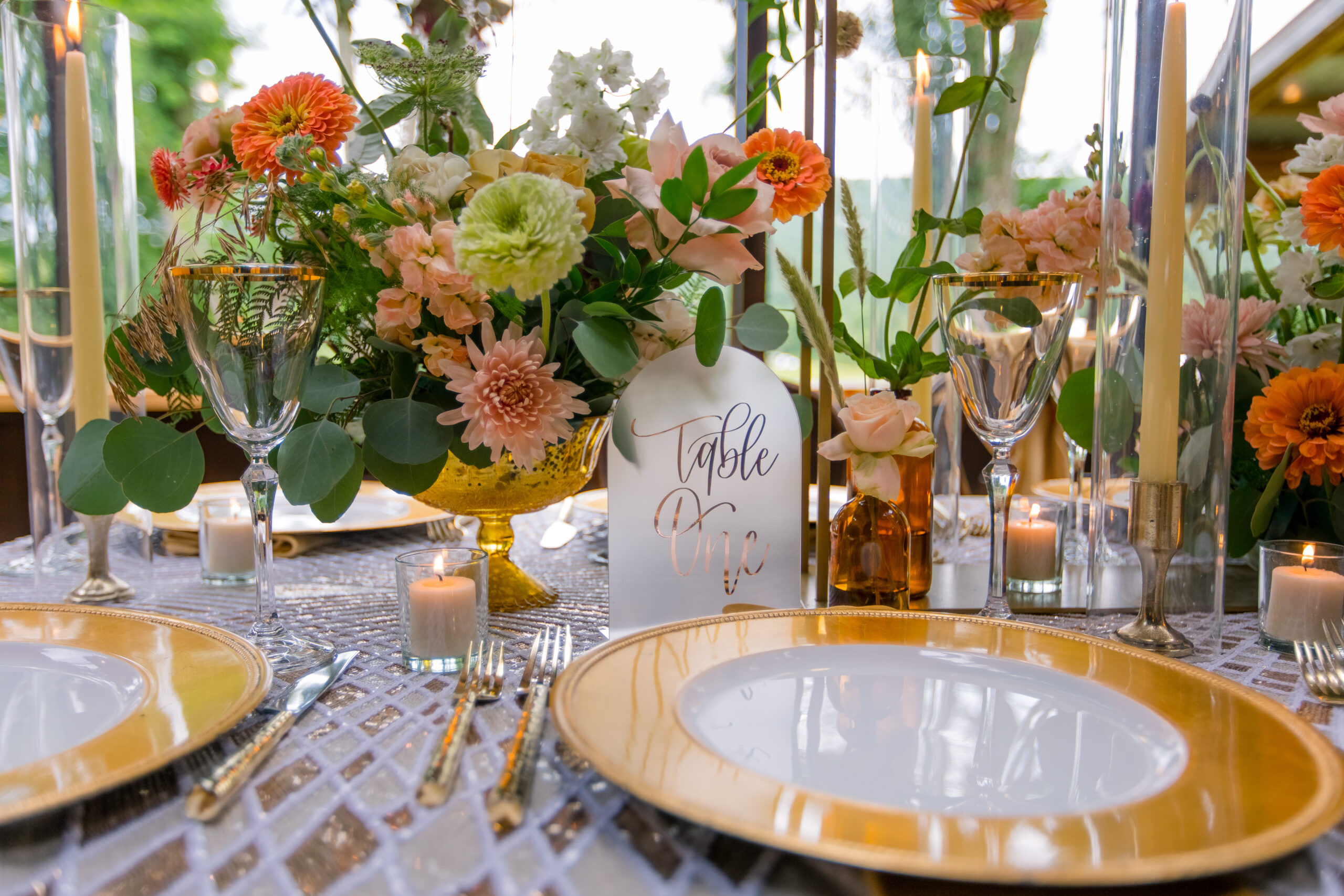 long table at wedding with gold chargers and fall colors