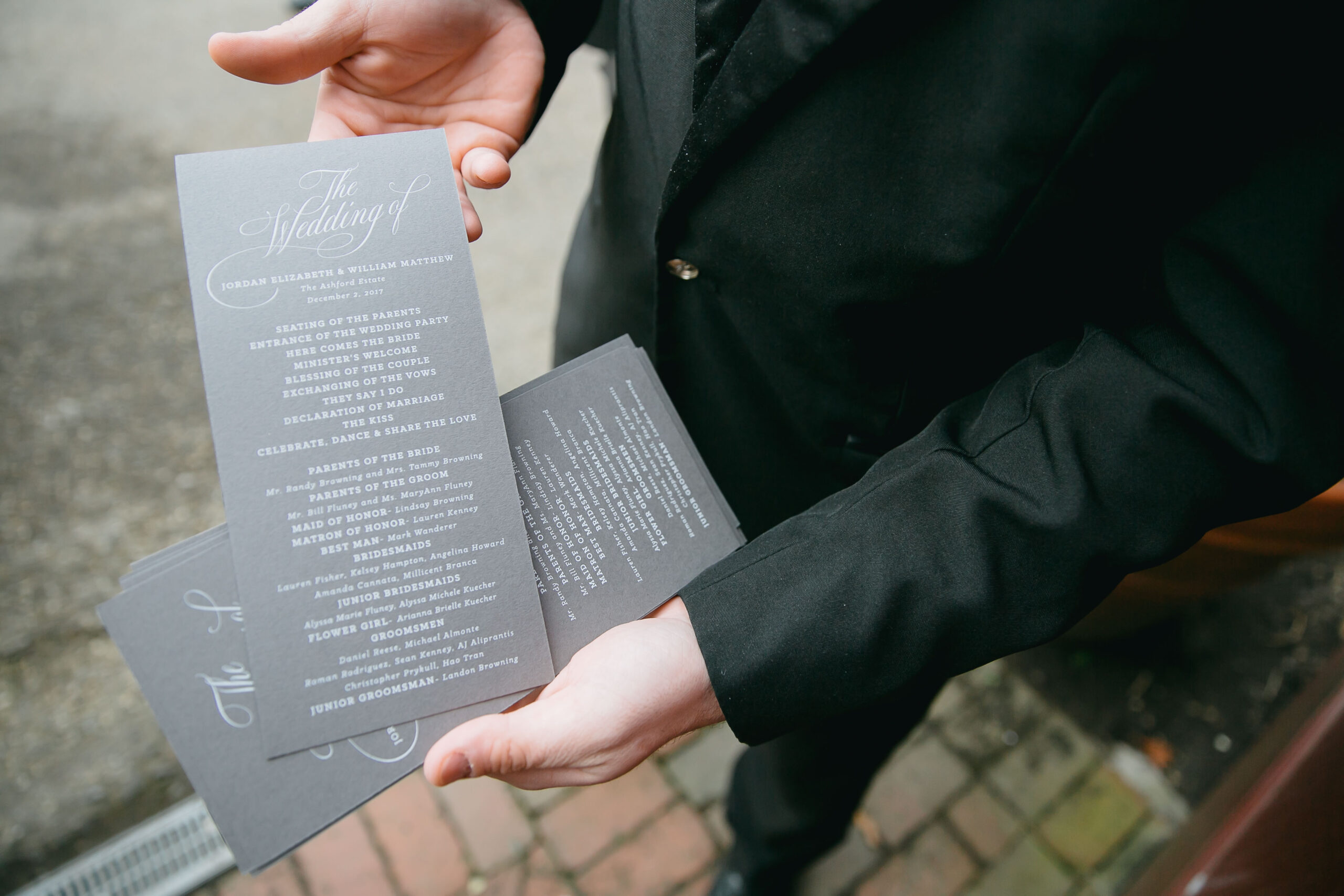 wedding ceremony programs with white calligraphy on gray