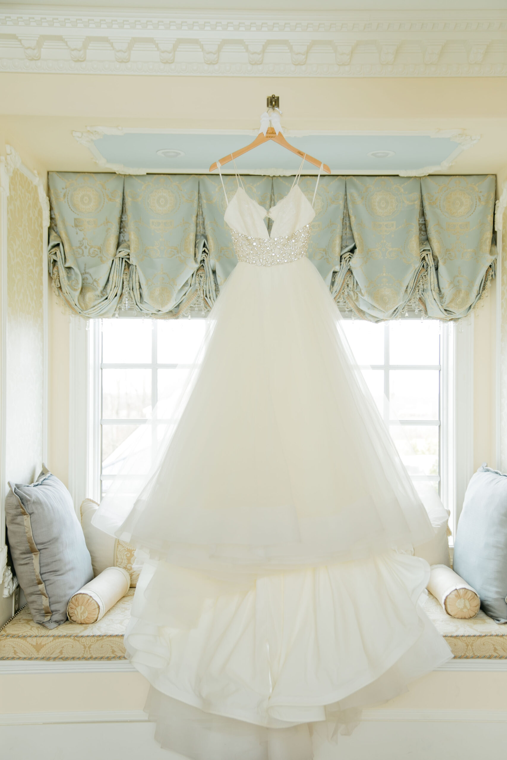 ballgown wedding dress hanging in window