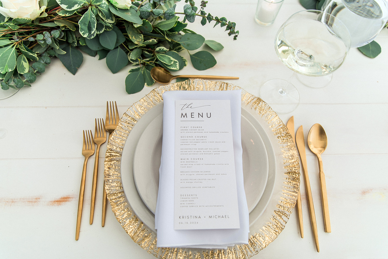 gold charger plates with gold flatware and a menu card