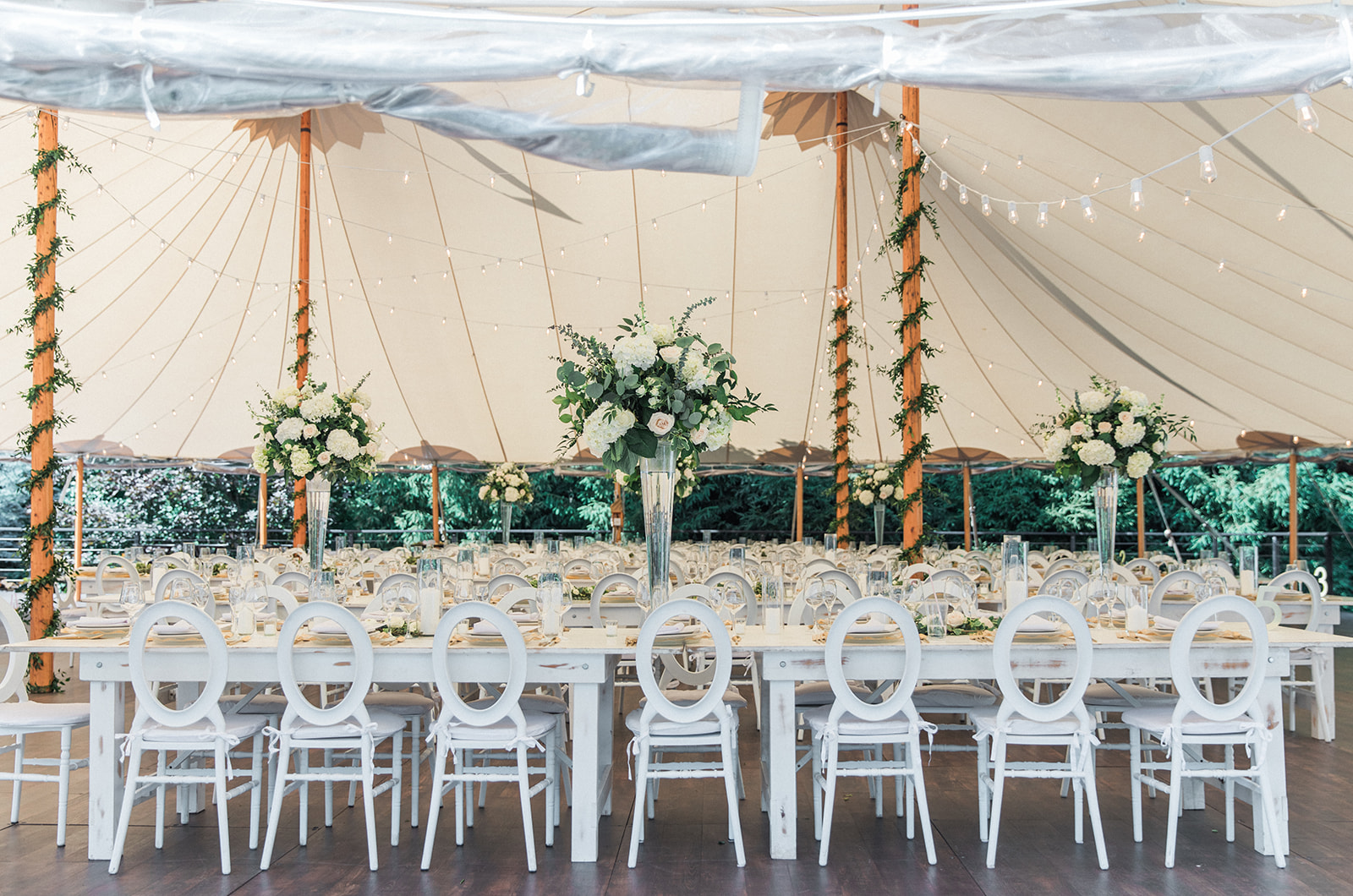 backyard wedding with tent and long white tables