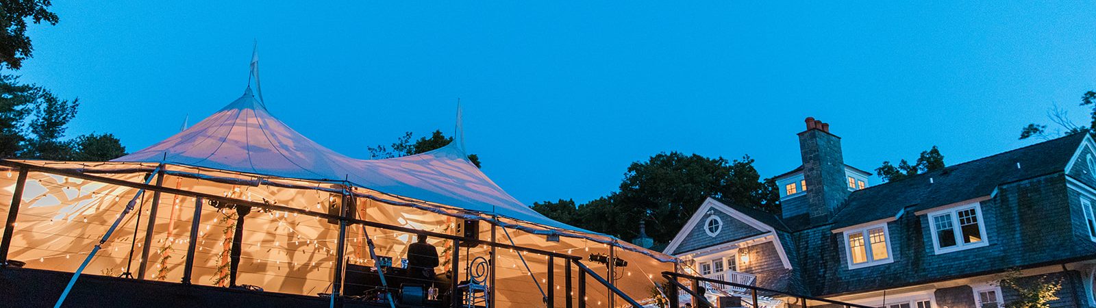 backyard wedding tent at night with lights