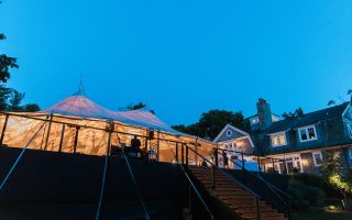 backyard wedding tent at night with lights