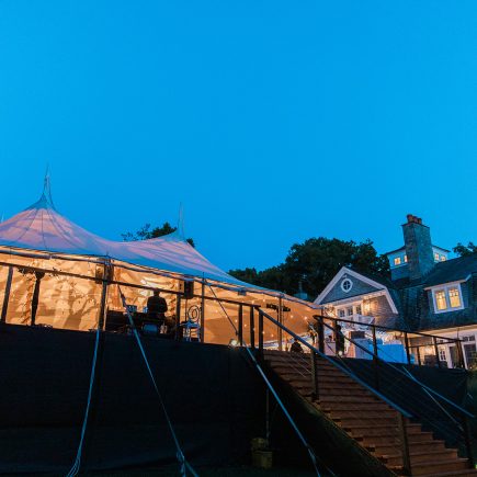 backyard wedding tent at night with lights