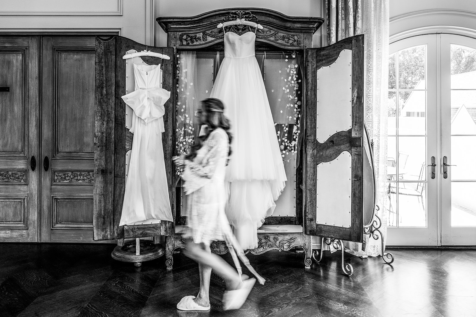 bride walking past her gown black and white photo