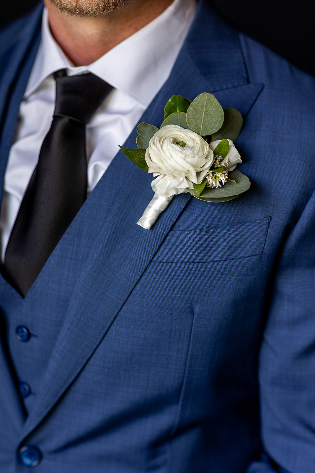 white flower boutineer for the groom blue suit