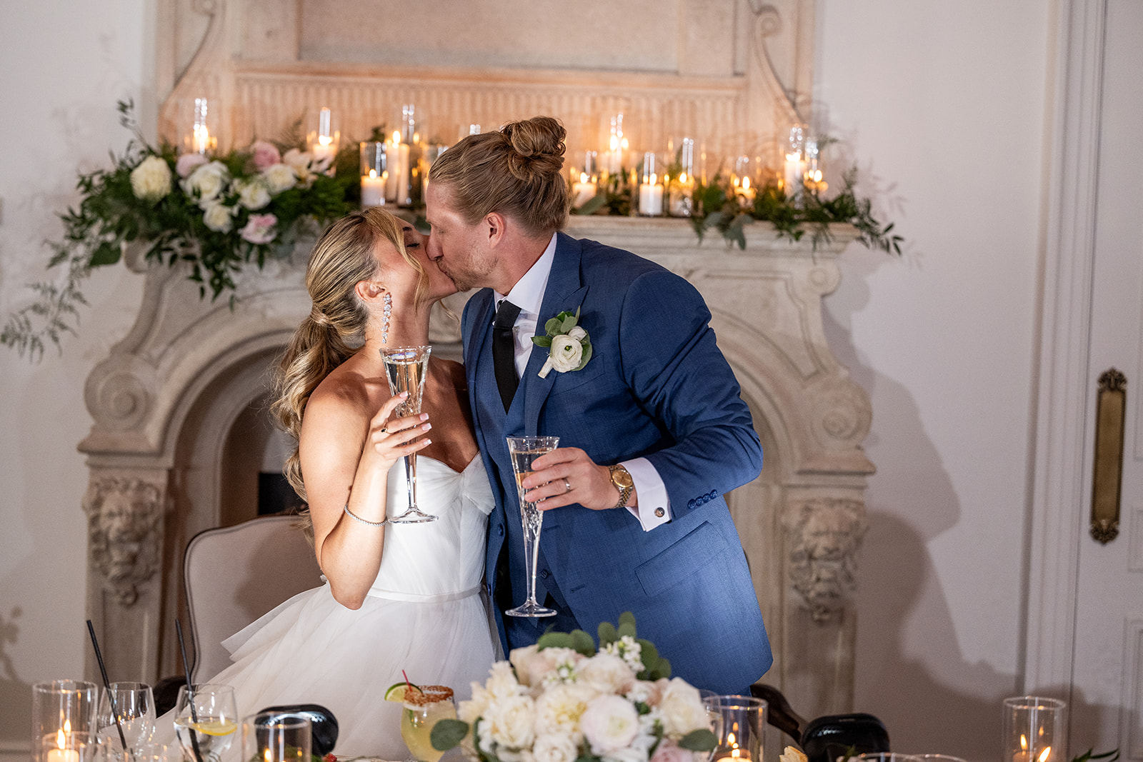 bride and groom kissing with champagne flutes