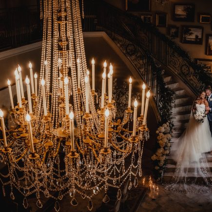 bride and groom with chandelier
