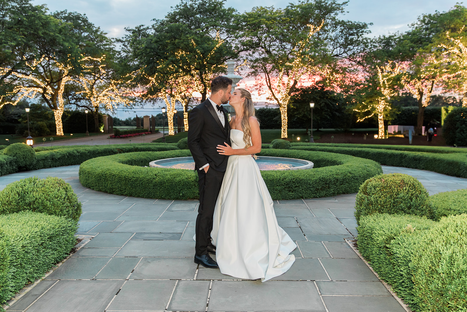 bride and groom outside with christmas lights on trees