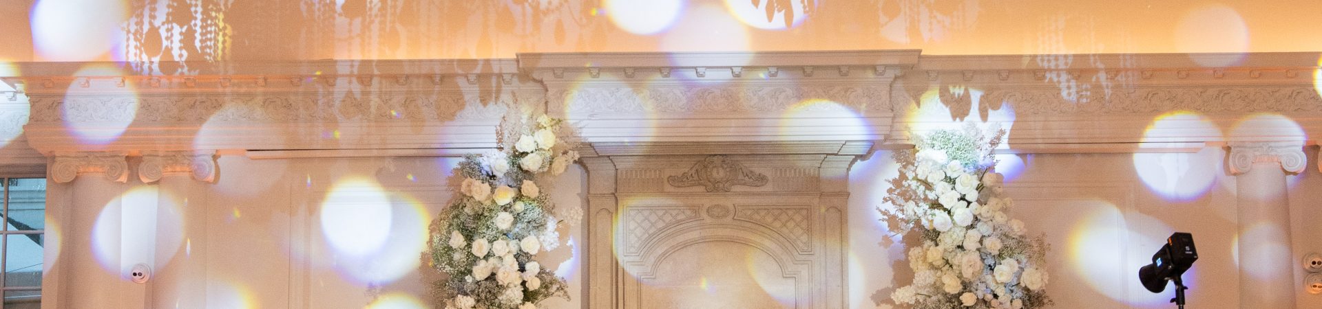 all white flowers at a wedding reception in a ballroom