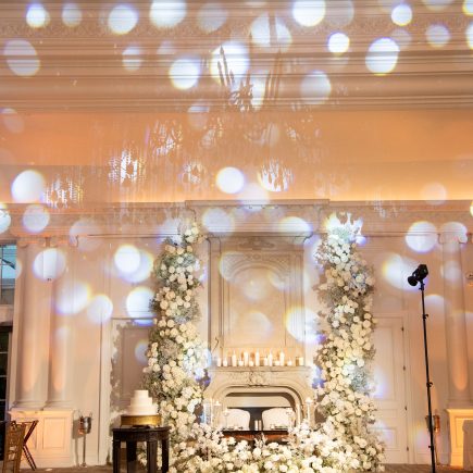all white flowers at a wedding reception in a ballroom