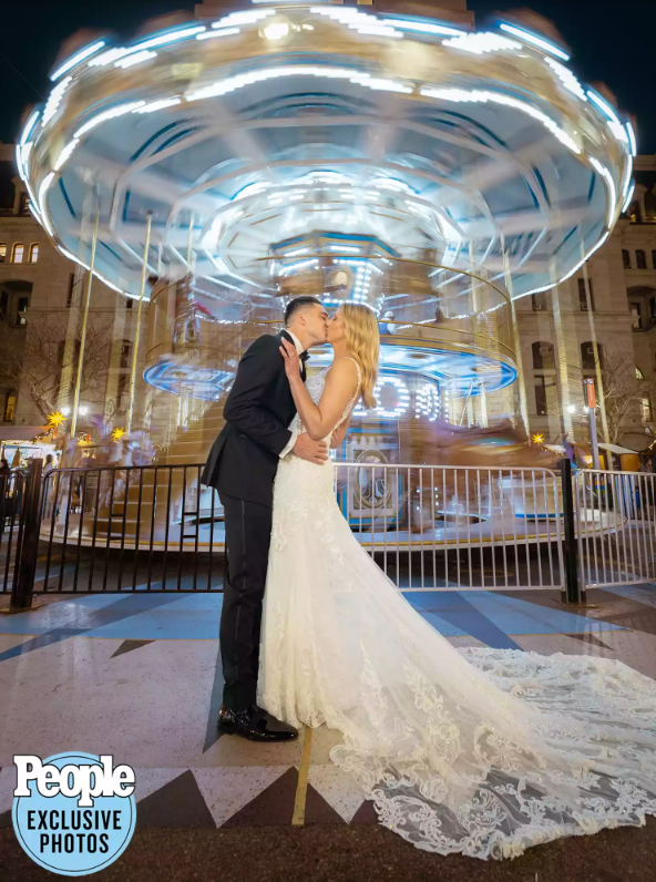 bride and groom kissing at carousel