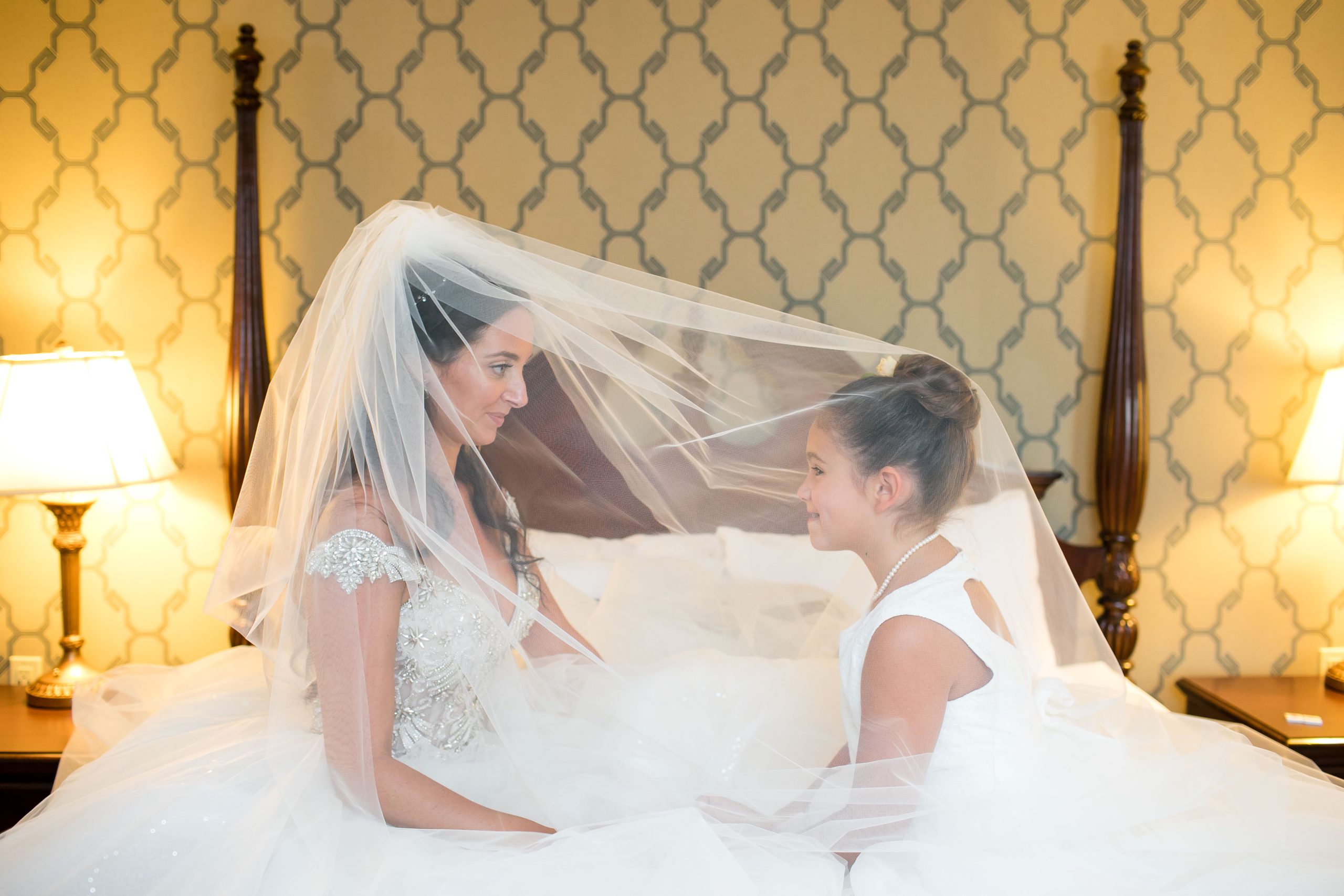 bride and flower girl under veil
